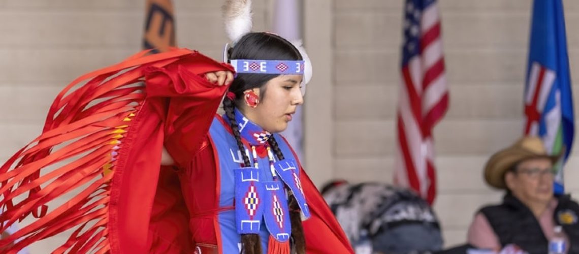 Calgary, Alberta, Canada. Jun 24, 2023. A medium shot of an indigenous woman talent showcase wearing a red traditional dress. National Indigenous Family Day and POW WOW. Aboriginal Awareness Week.